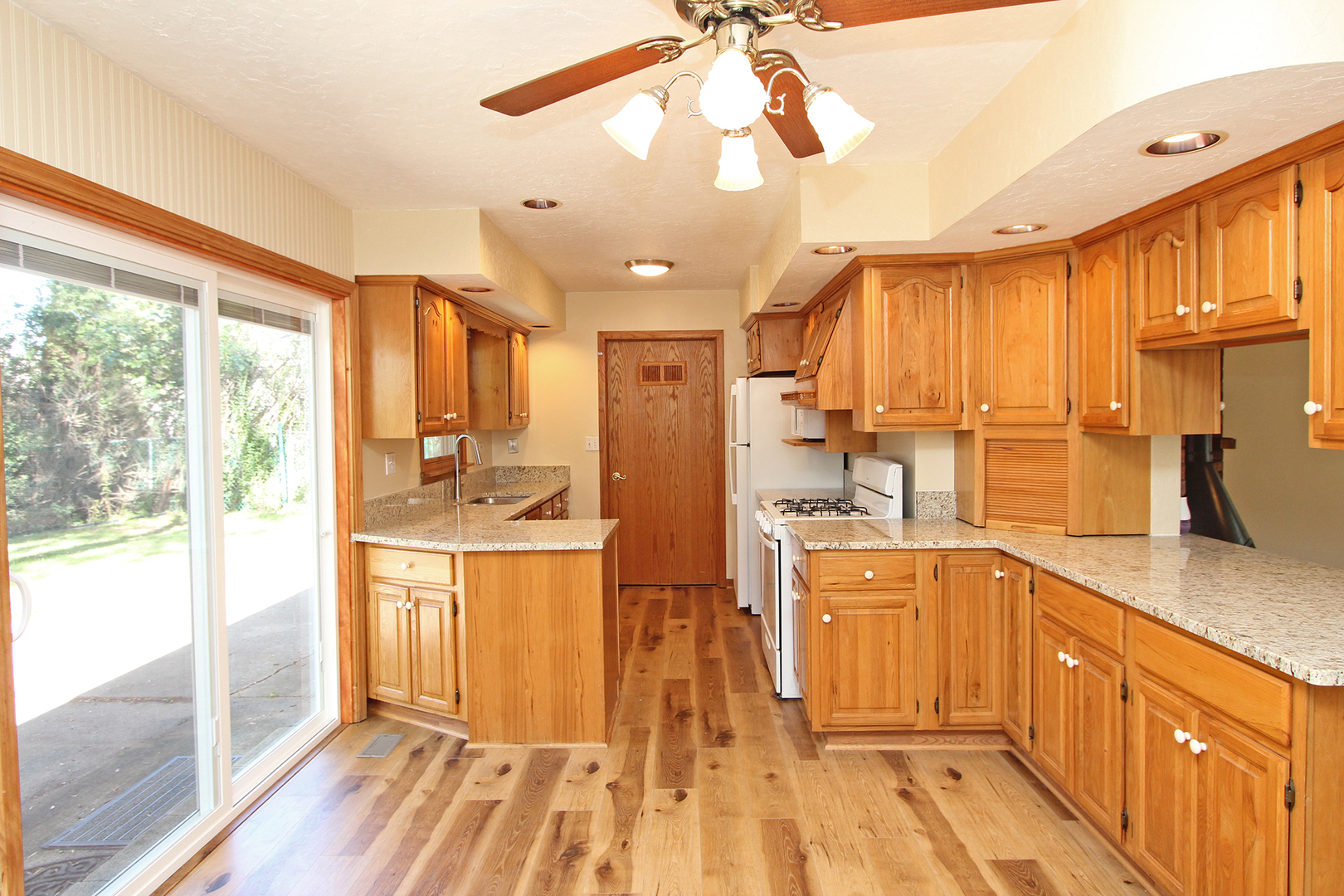 65 Old Mill Grove Road Lake Zurich, IL 60047 - Photo 8 of 29 a kitchen with stainless steel appliances granite countertop a refrigerator a sink dishwasher a stove and white countertops with wooden floor