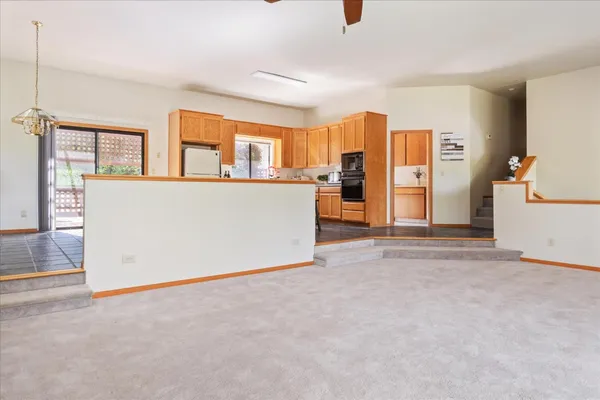 a kitchen with stainless steel appliances granite countertop a refrigerator a sink a stove a washer dryer and a window