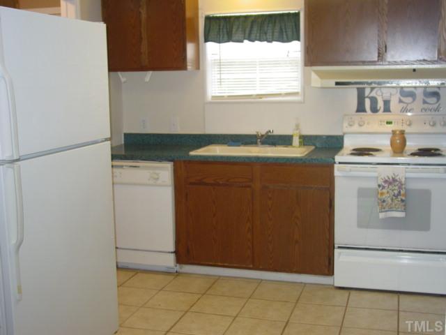 8116 Bacon Road Timberlake, NC 27583 - Photo 3 of 15 Kitchen has tiled floor, washer and dryer and pantry space as well. Appliances included. Washer, dryer, refrigerator and stove & stove w/ range hood.