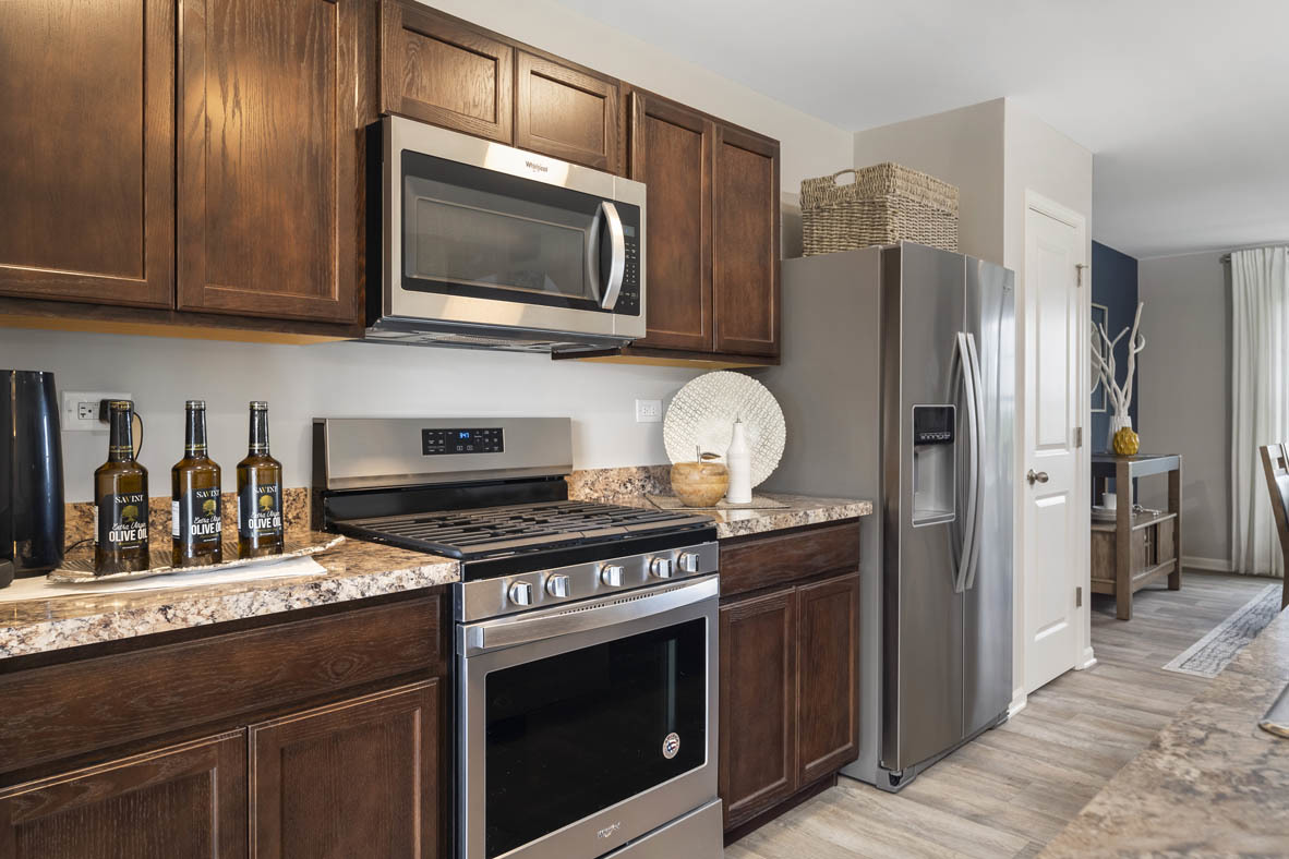 3728 Bailey Road Yorkville, IL 60560 - Photo 4 of 16 a kitchen with stainless steel appliances granite countertop a stove microwave refrigerator and sink