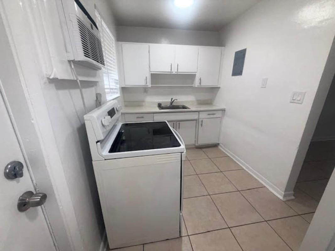 6008 Northwest 10th Street, Unit 3 Pompano Beach, FL 33063 - Photo 5 of 8 a kitchen with a sink a stove and cabinets