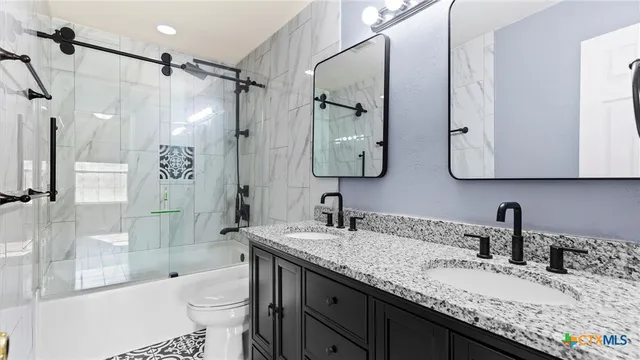 a bathroom with a granite countertop sink toilet and shower