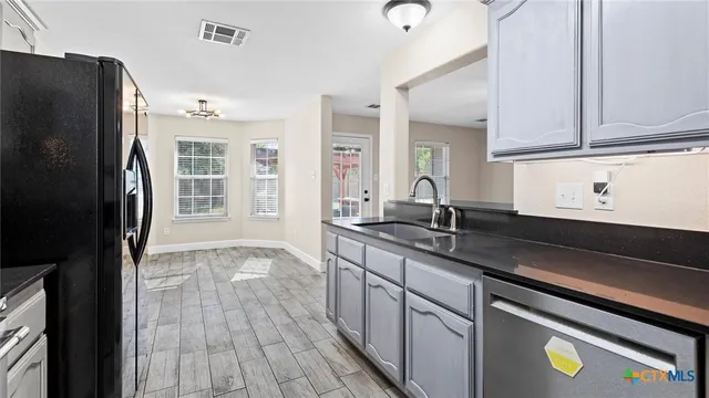 a kitchen with stainless steel appliances granite countertop a refrigerator and a sink