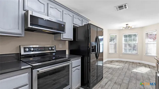 a kitchen with stainless steel appliances granite countertop a stove microwave and refrigerator