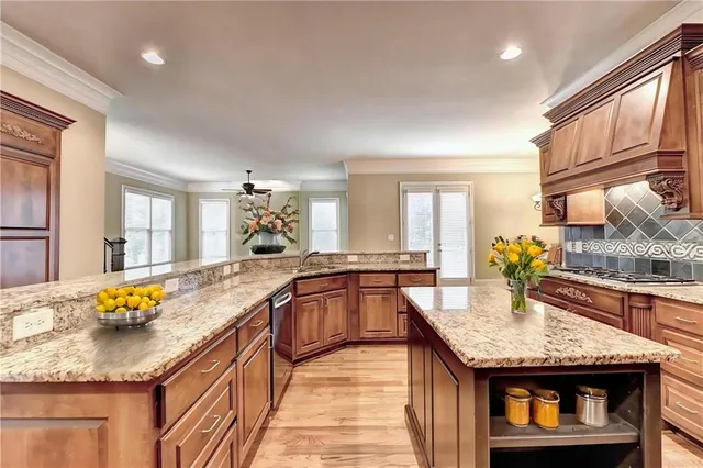 a large kitchen with stainless steel appliances granite countertop a stove and a view of living room