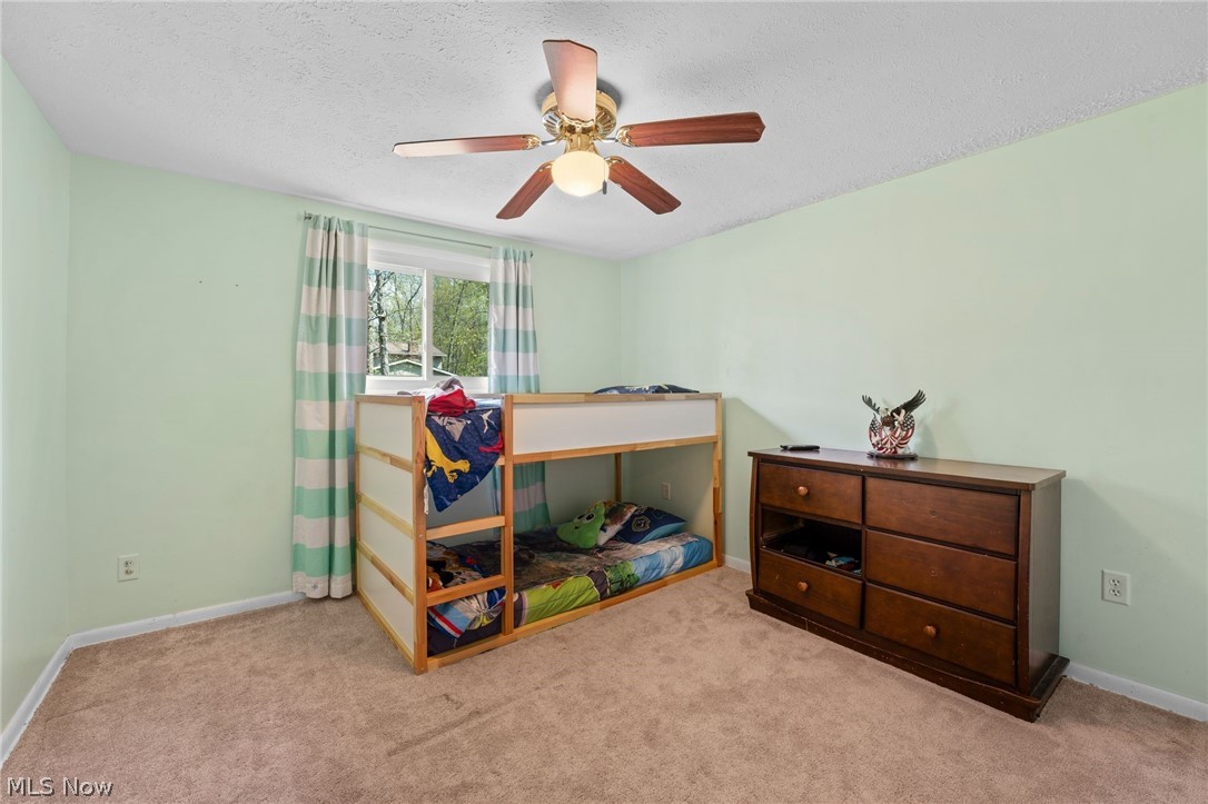 3223 Sandy Lake Road Ravenna, OH 44266 - Photo 23 of 30 Carpeted bedroom with ceiling fan and a textured ceiling