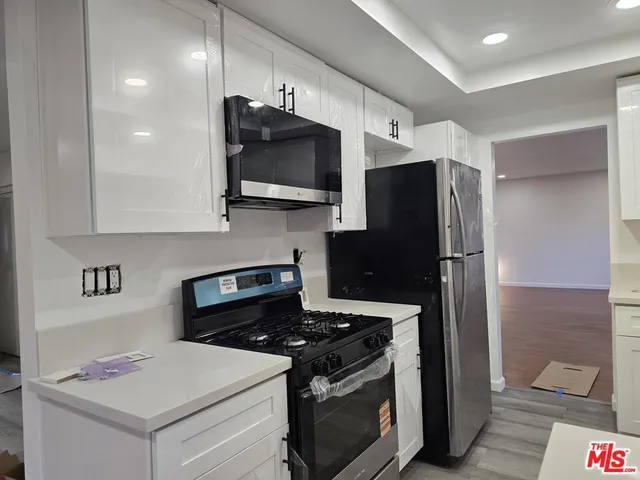 a kitchen with stainless steel appliances kitchen island a stove and a refrigerator