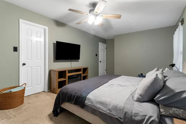 a bedroom with a bed and a flat screen tv