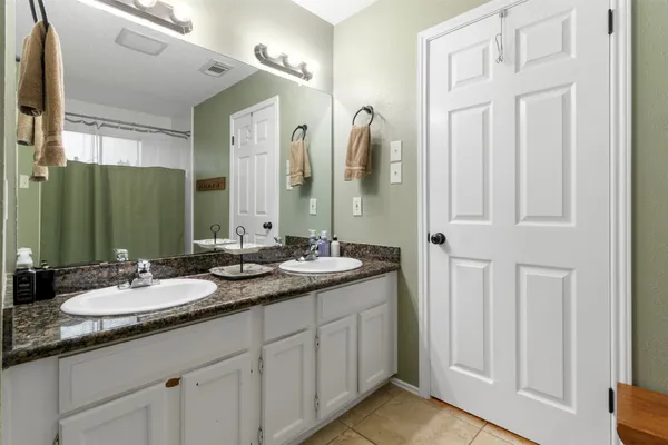 a bathroom with double vanity sinks and a mirror