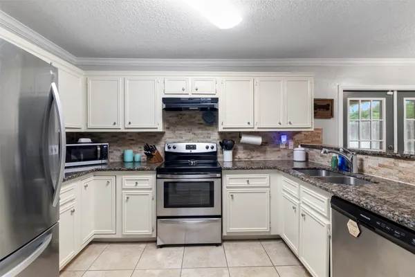 a kitchen with stainless steel appliances granite countertop a stove sink and cabinets