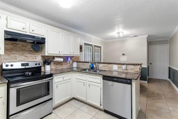 a kitchen with stainless steel appliances granite countertop a stove and cabinets