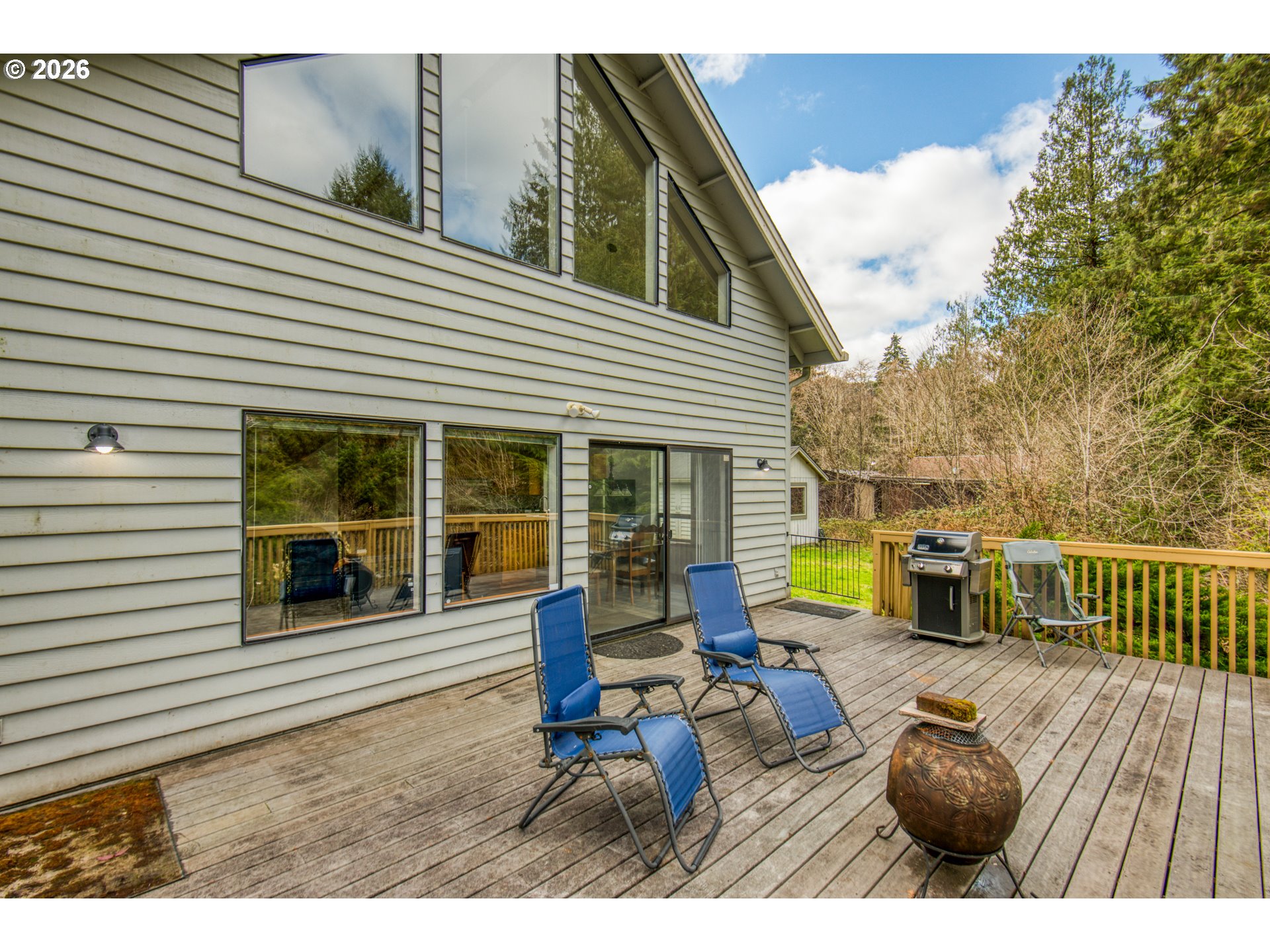 78488 Highway 53 Nehalem, OR 97131 - Photo 26 of 40 a view of a deck with couches table and chairs and potted plants