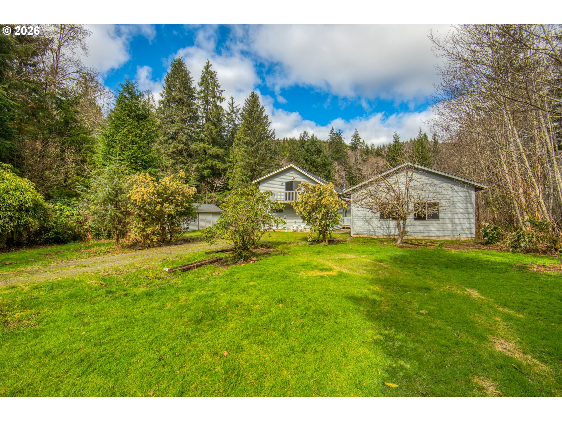 78488 Highway 53 Nehalem, OR 97131 - Photo 4 of 40 a view of a big house with a big yard and large trees