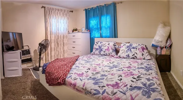 a bedroom with a bed and a television
