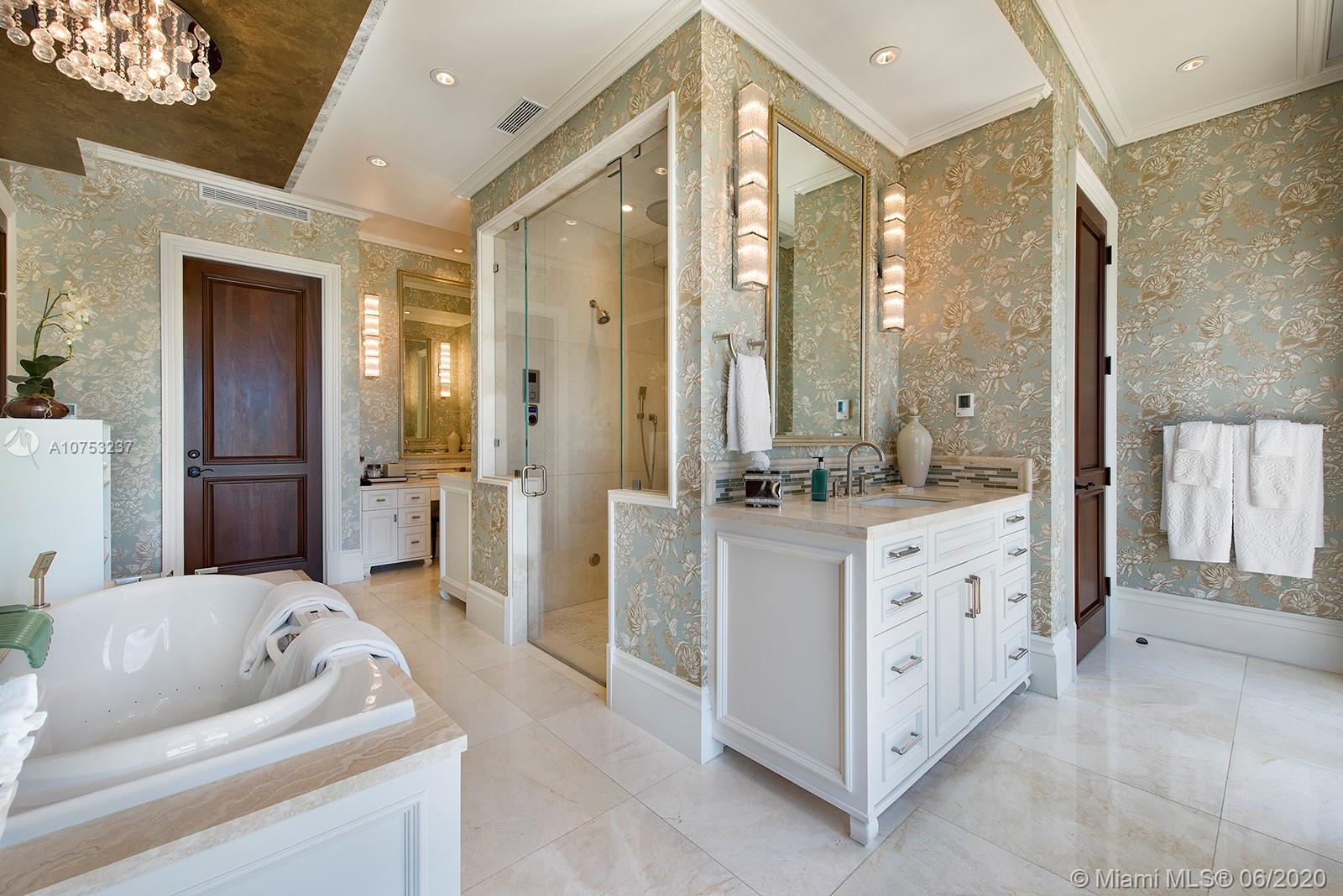 7825 Atlantic Way Miami Beach, FL 33141 - Photo 24 of 38 a spacious bathroom with a double vanity sink a large mirror and a shower