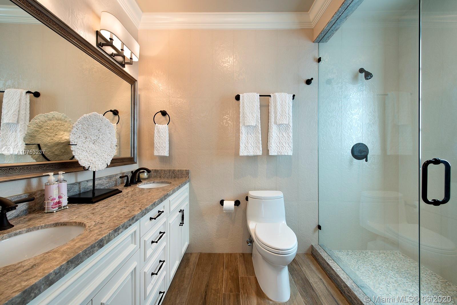 7825 Atlantic Way Miami Beach, FL 33141 - Photo 27 of 38 a bathroom with a granite countertop toilet sink and shower