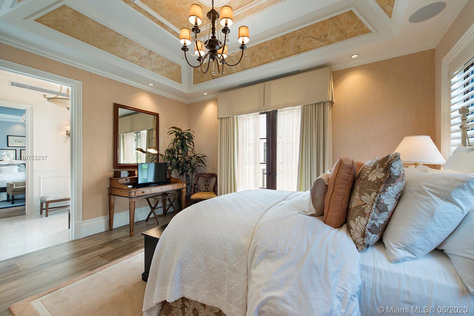 7825 Atlantic Way Miami Beach, FL 33141 - Photo 29 of 38 a bedroom with a large bed chandelier and a window