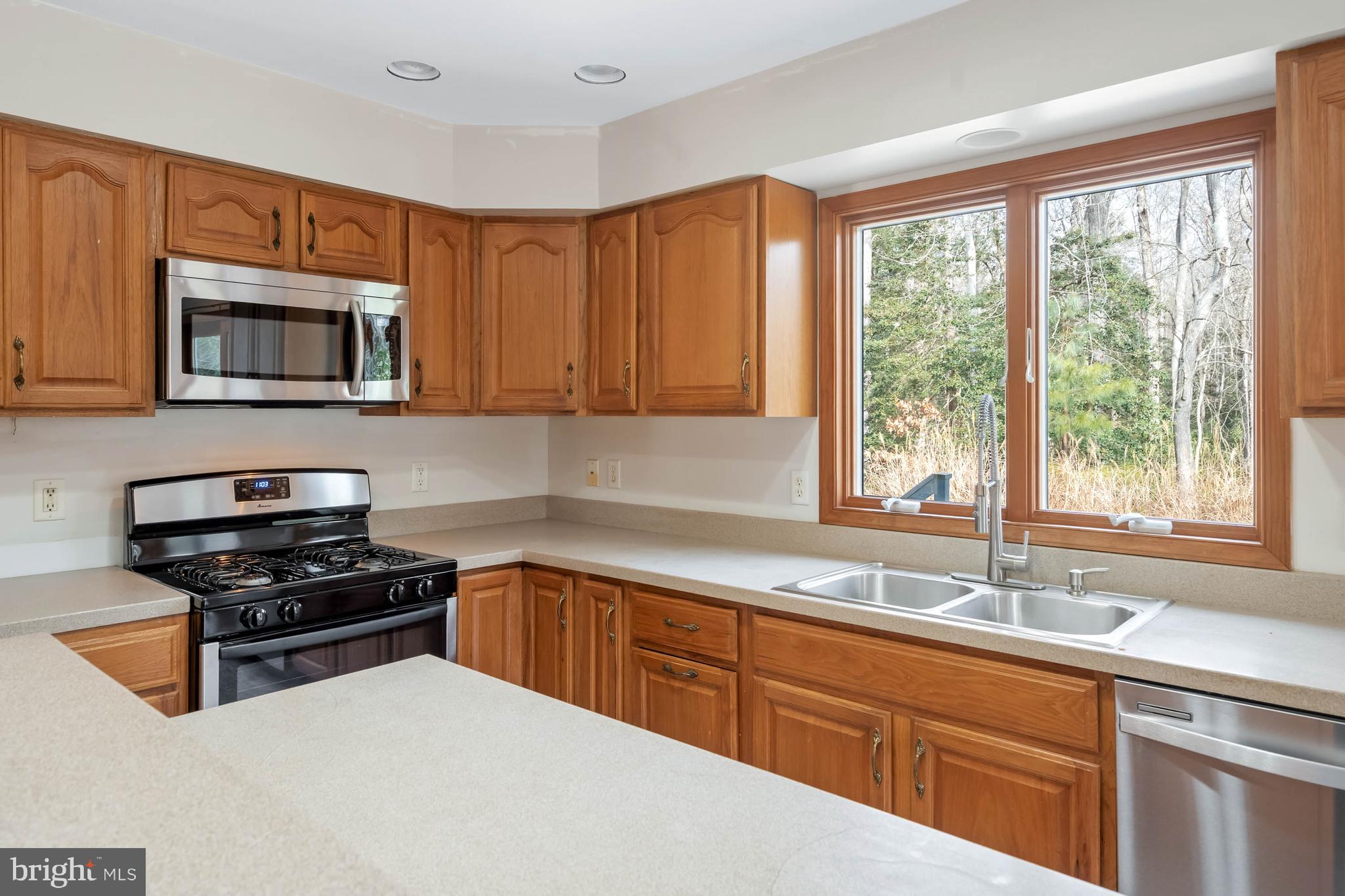 18885 Sand Hill Road Milton, DE 19968 - Photo 14 of 46 a kitchen with granite countertop a sink a stove top oven a cabinetry and a window