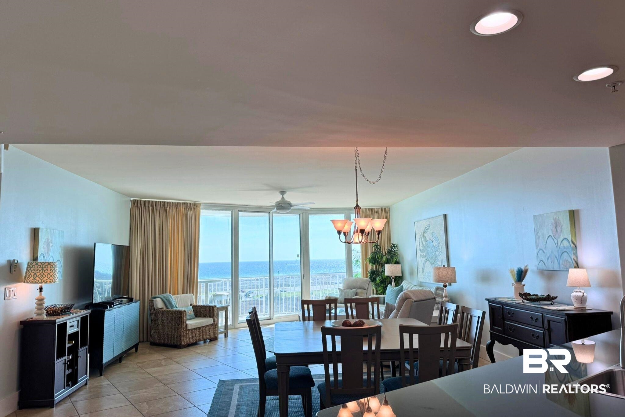 28107 Perdido Beach Boulevard, Unit D714 Orange Beach, AL 36561 - Photo 13 of 88 Dining space with ceiling fan with notable chandelier, light tile patterned floors, and a wall of windows