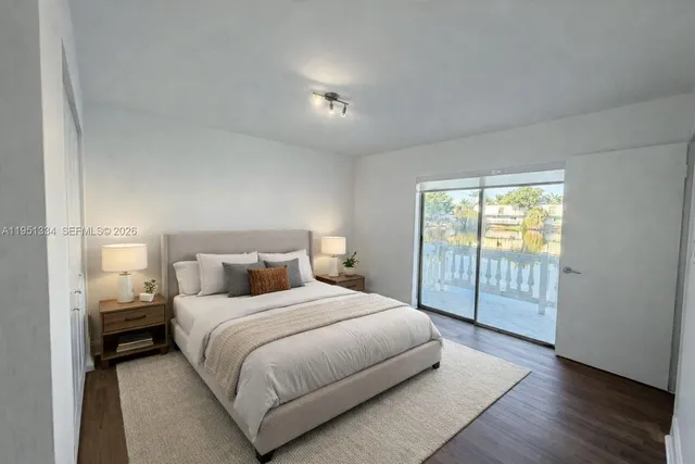 a bedroom with a large bed and wooden floor
