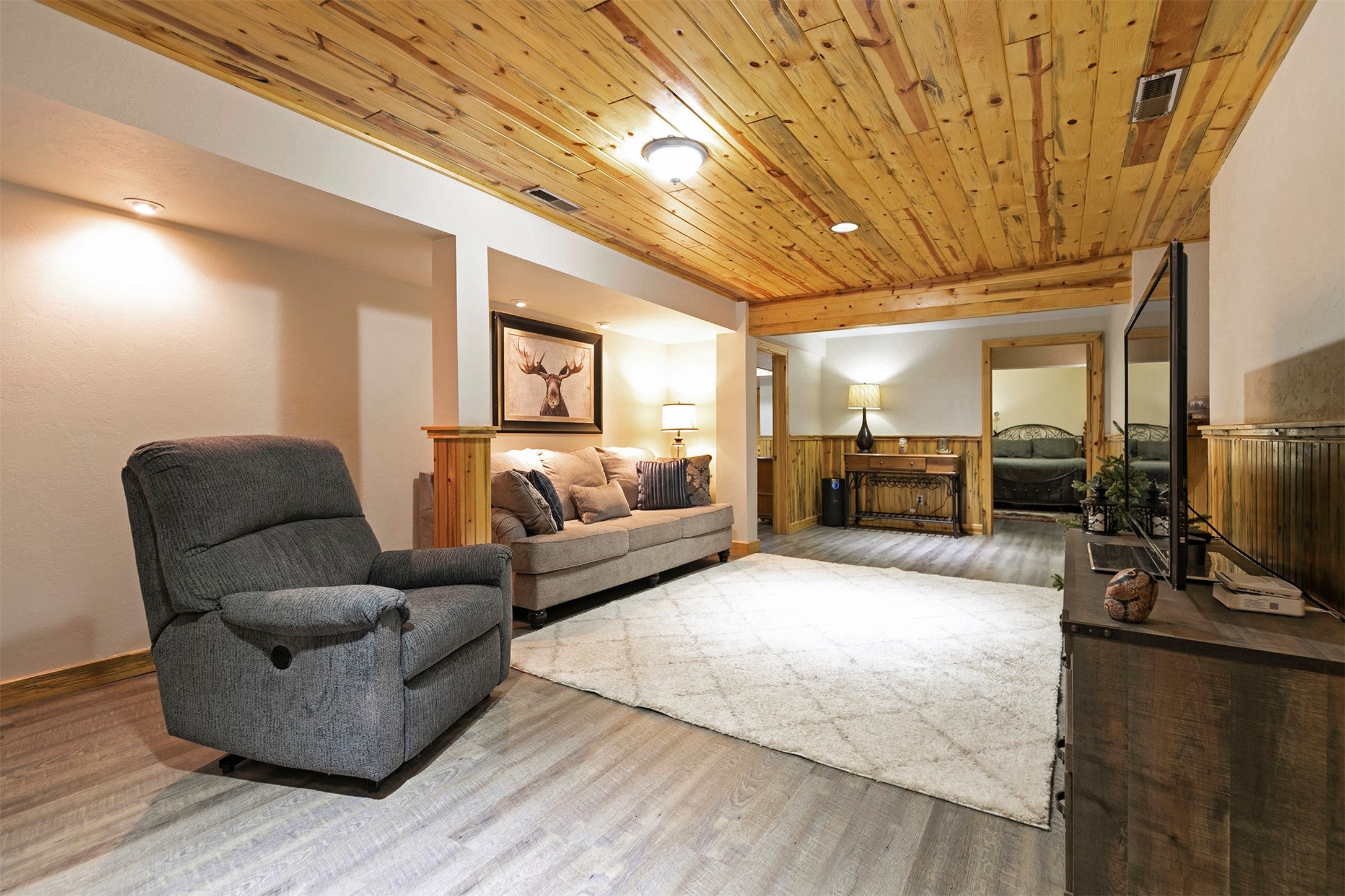 203 Hart Bench Road Darby, MT 59829 - Photo 25 of 56 Spacious and inviting, the basement living area is enhanced by a tongue-and-groove ceiling, combining rustic charm with refined style.