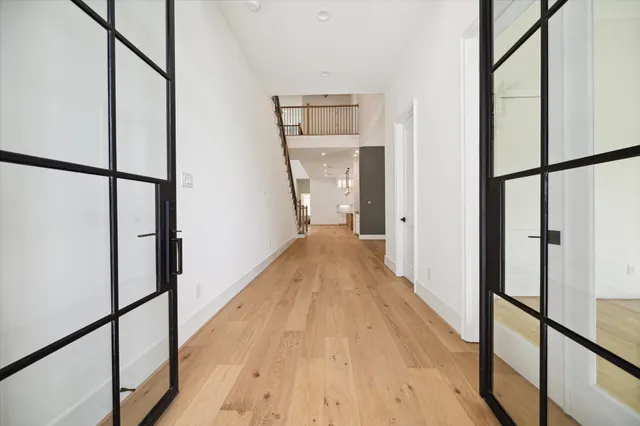 a view of a hallway with wooden floor and staircase