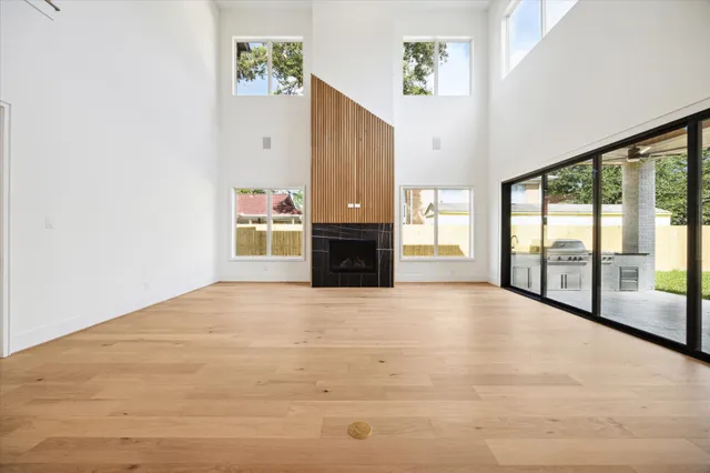 a view of an empty room with a fireplace and a window