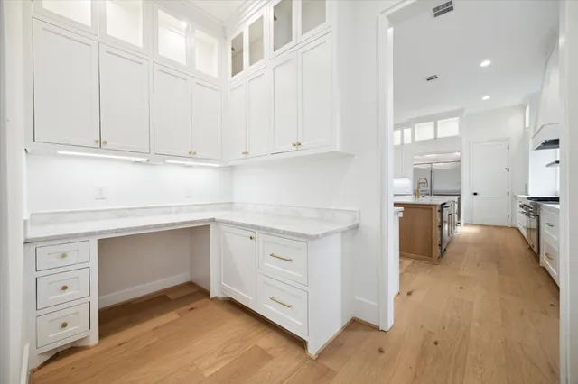 a kitchen with cabinets appliances and a wooden floor