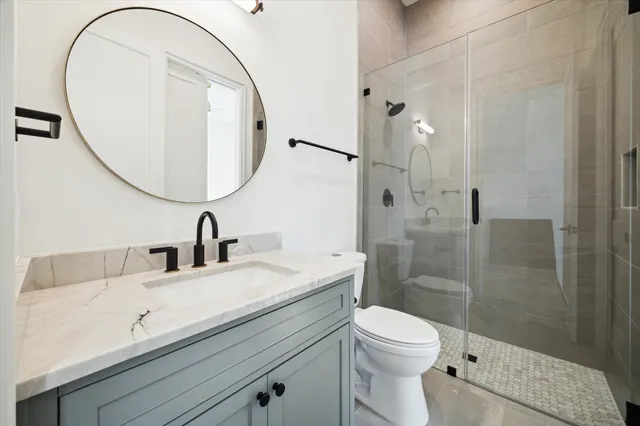 a bathroom with a sink a toilet and a mirror