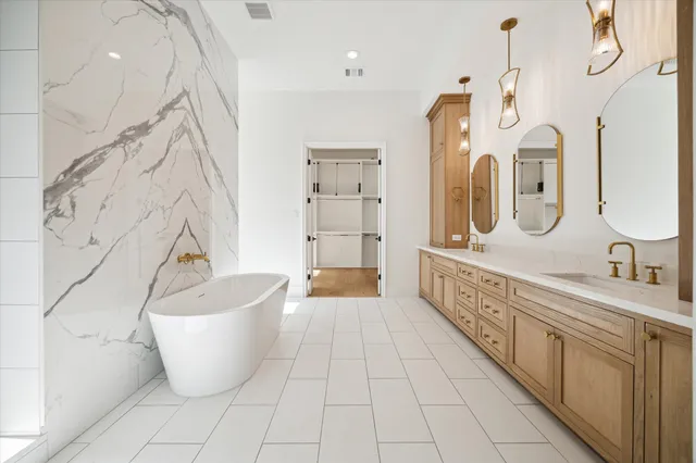 a spacious bathroom with a bathtub sink and mirror