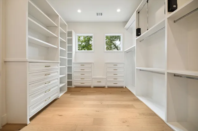 a view of walk in closet with empty racks