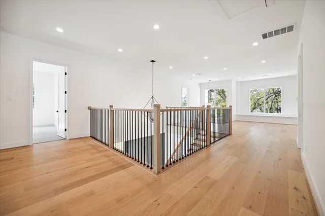 a view of a hallway with wooden floor and windows