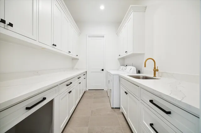 a view of a kitchen sink with white cabinets