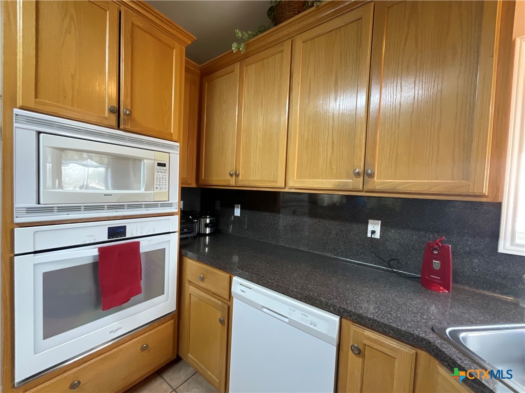 2826 Cattle Guard Road Cuero, TX 77954 - Photo 40 of 48 a kitchen with stainless steel appliances granite countertop cabinets and a wooden floor
