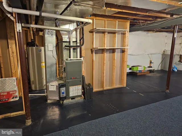 a view of water heater room with wooden floor