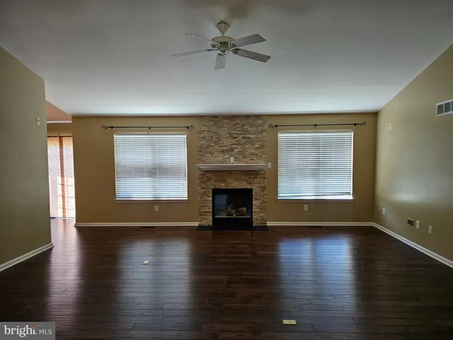 wooden floor fireplace and windows in an empty room