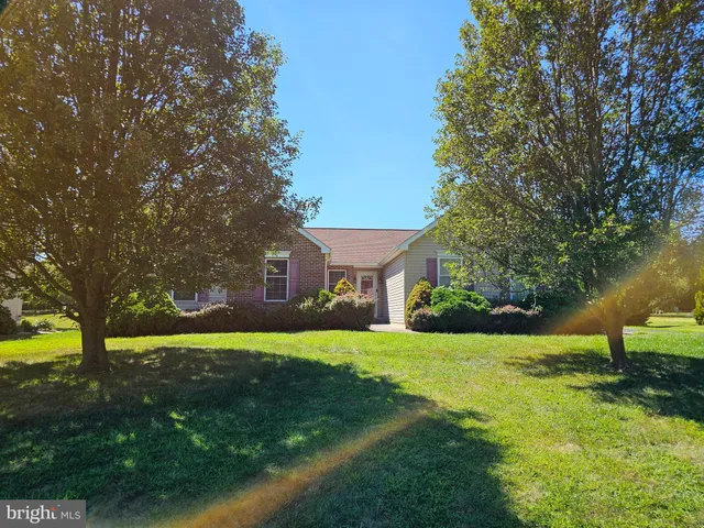 a view of a house with a big yard and large trees