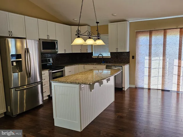 a kitchen with wooden cabinets and stainless steel appliances