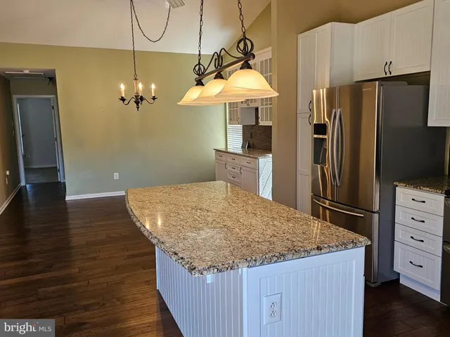 a kitchen with stainless steel appliances granite countertop a refrigerator a sink and a stove