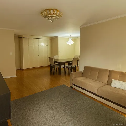 a living room with couches and a dining table with painted walls