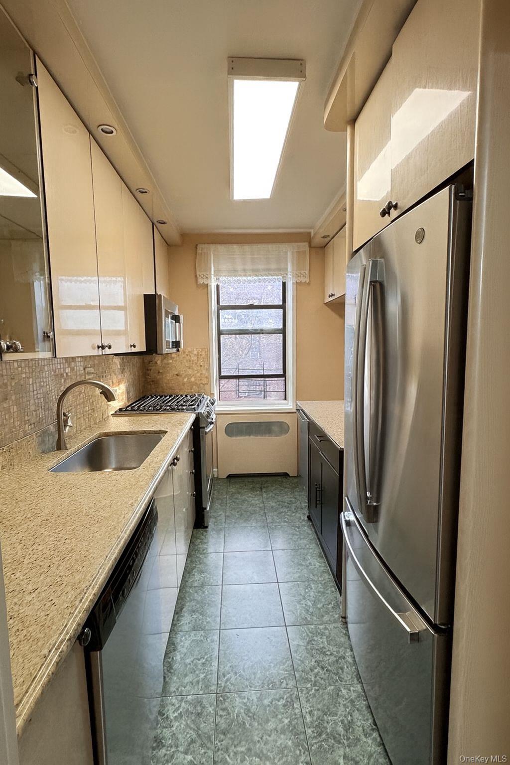 141-05 Pershing Crescent, Unit 416 Queens, NY 11435 - Photo 5 of 17 a kitchen with a refrigerator and a sink