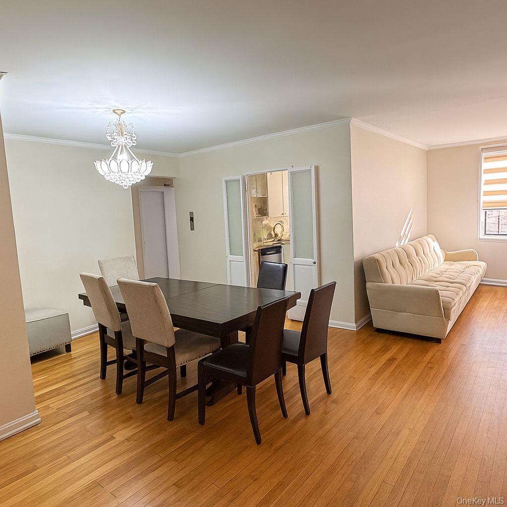 141-05 Pershing Crescent, Unit 416 Queens, NY 11435 - Photo 6 of 17 a view of a dining room with furniture and wooden floor