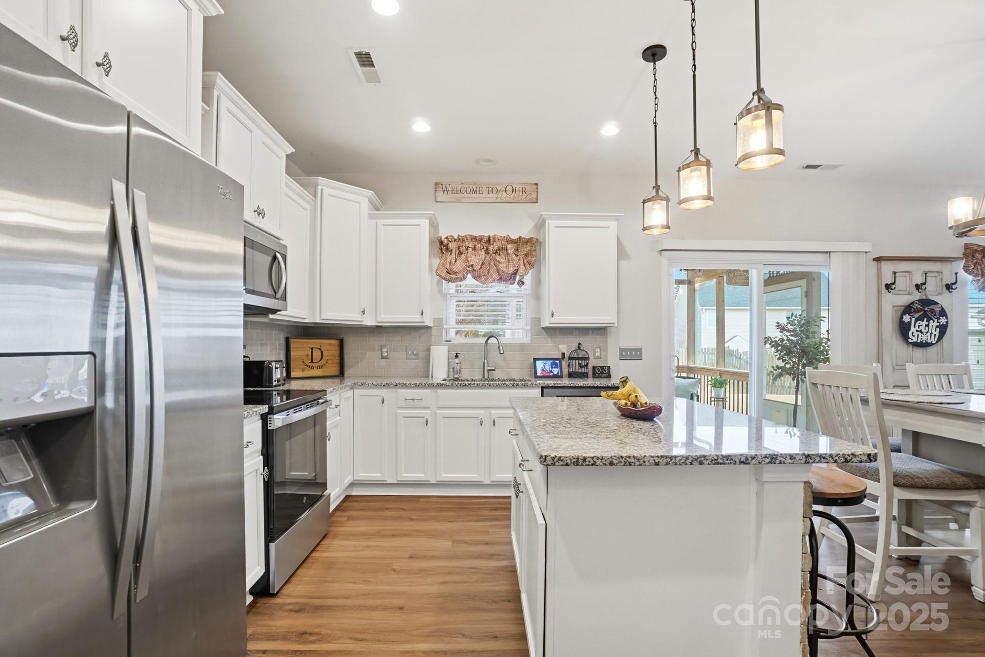 5033 Haven Lodge Road Matthews, NC 28104 - Photo 15 of 37 a kitchen with stainless steel appliances granite countertop a refrigerator a stove and white cabinets