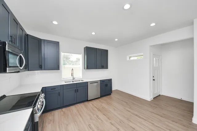 a kitchen with granite countertop a sink and a stove top oven