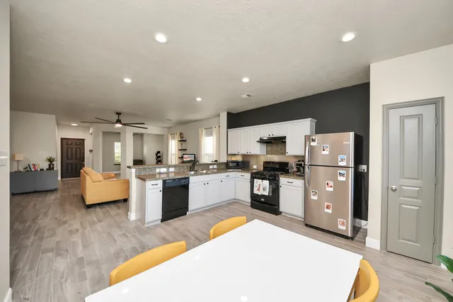 a large kitchen with stainless steel appliances granite countertop a lot of counter space and wooden floor