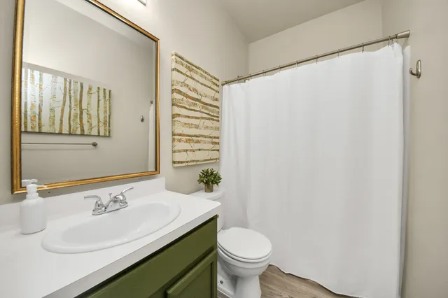 an empty room with wooden floor closet and ceiling fan