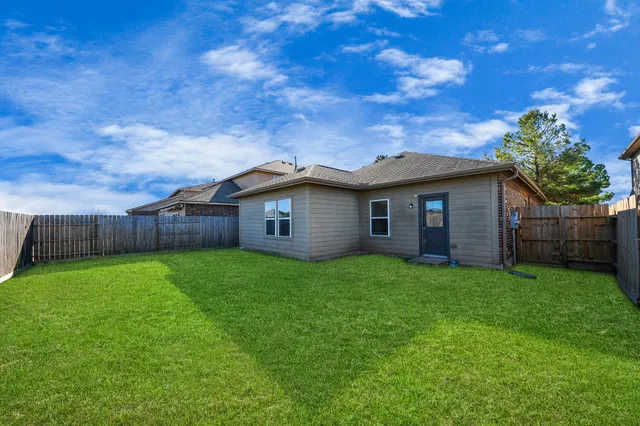 a view of a backyard with wooden fence