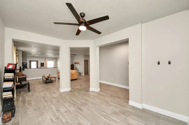 a view of a livingroom with wooden floor and a ceiling fan