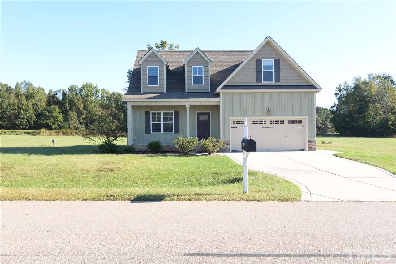 179 Red Wood Road Zebulon, NC 27597 - Photo 2 of 25 a front view of a house with a garden and a garage