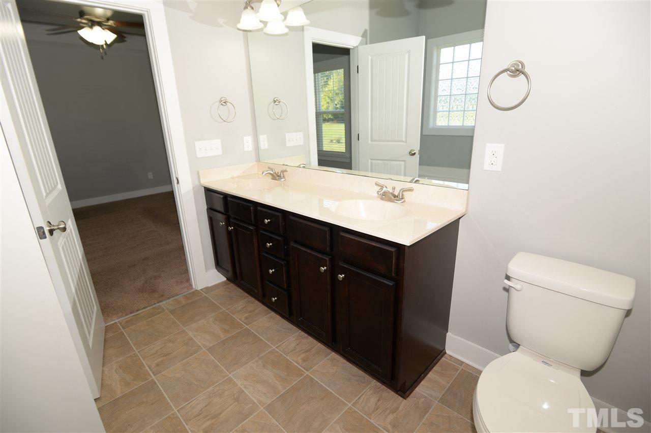 179 Red Wood Road Zebulon, NC 27597 - Photo 18 of 25 a bathroom with a sink vanity mirror and toilet
